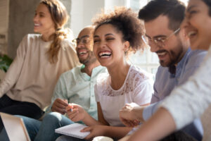 A group of students working and laughing together, writing in a notebook